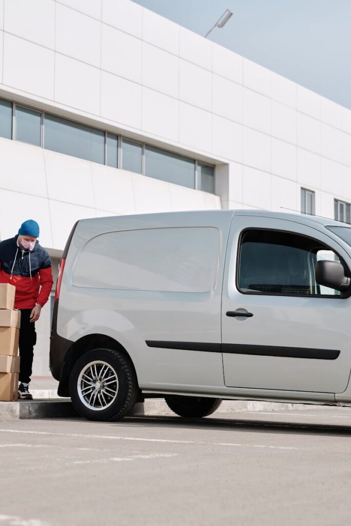 Delivery Man With Boxes next to a White Van